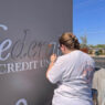 Piper Family Painting team member detailing a commercial sign during a Tucson painting project.