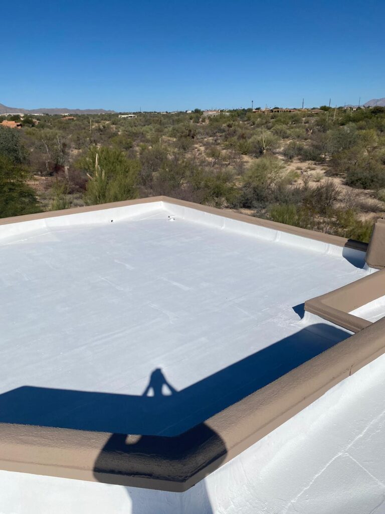 Flat roof with reflective roof coatings by Piper Family Painting Company in a sunny desert setting, enhancing energy efficiency and roof protection.