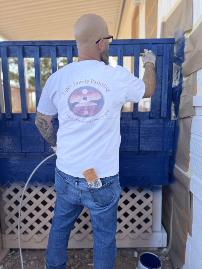 Oro Valley Painting Company expert from Piper Family Painting Company applies bold blue paint to wood, showcasing precision, care, and vibrant transformation.